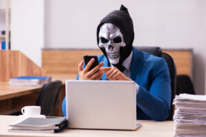 man in skull mask in office working
