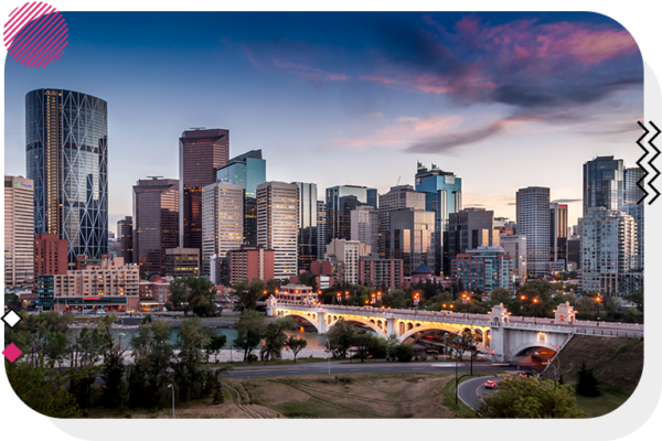 Calgary skyline with a river and a bridge at sunset