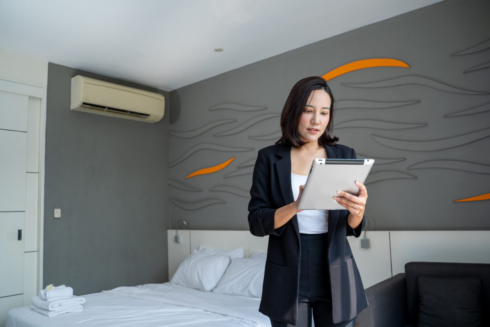 Woman in hotel room looking at tablet
