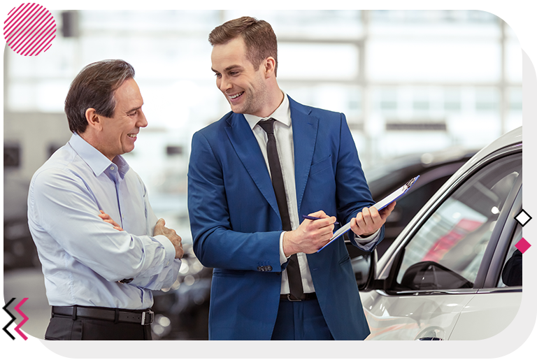 Man showing another man some papers on a clipboard in front of a car