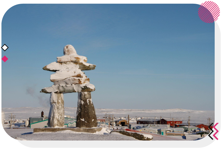 An inukshuk in the middle of a small Nunavut town
