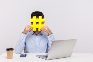 Man holding a hashtag over his face